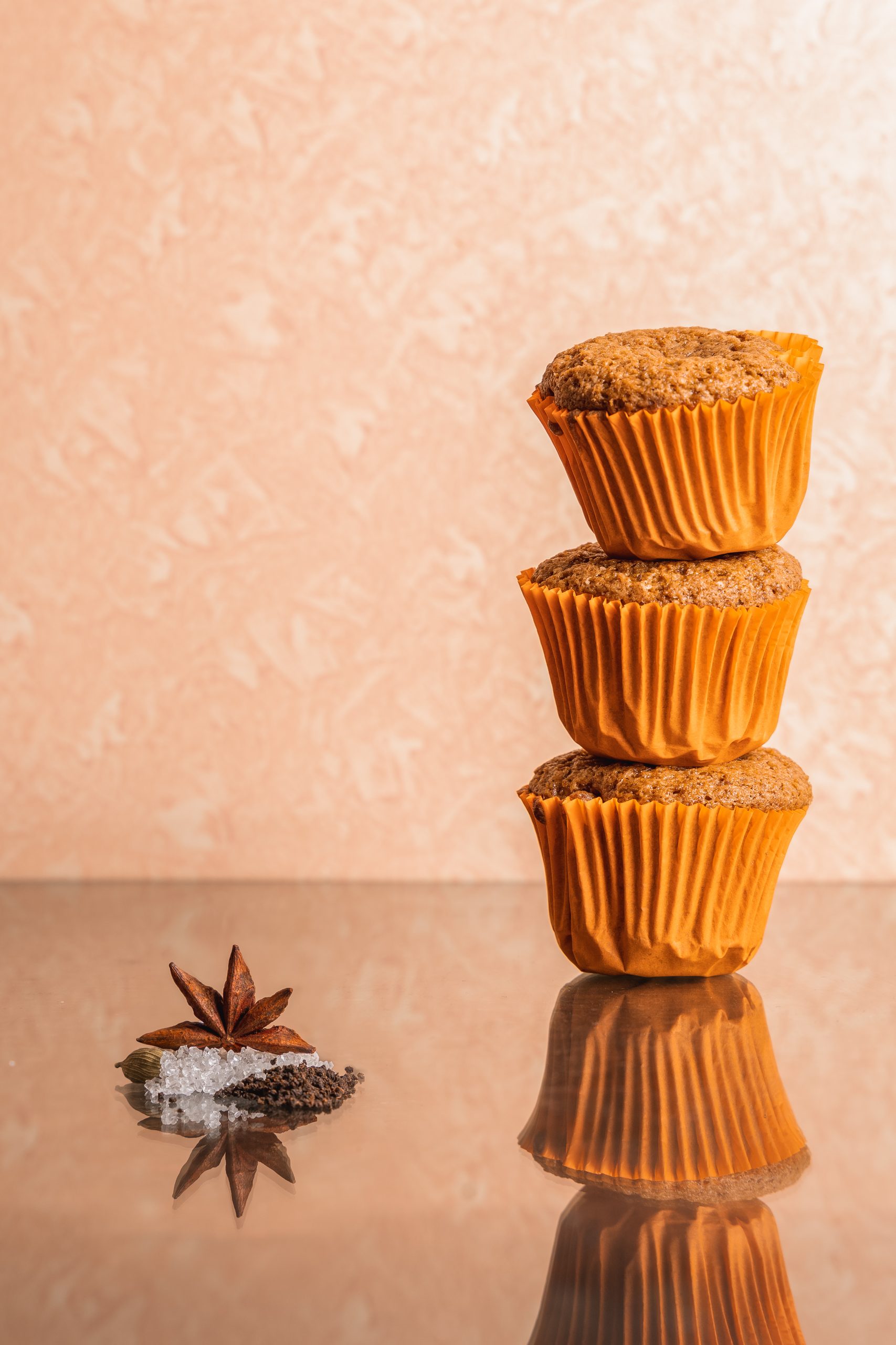 Stack of muffins on a peach ground with star anise