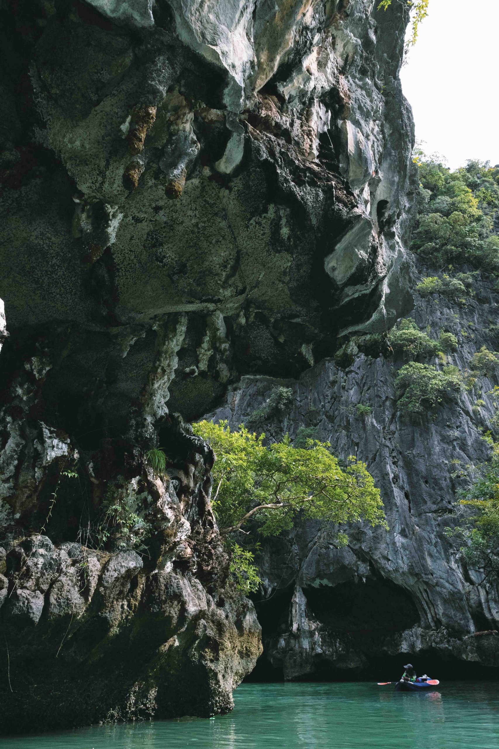 Limestone cliff rising from green water