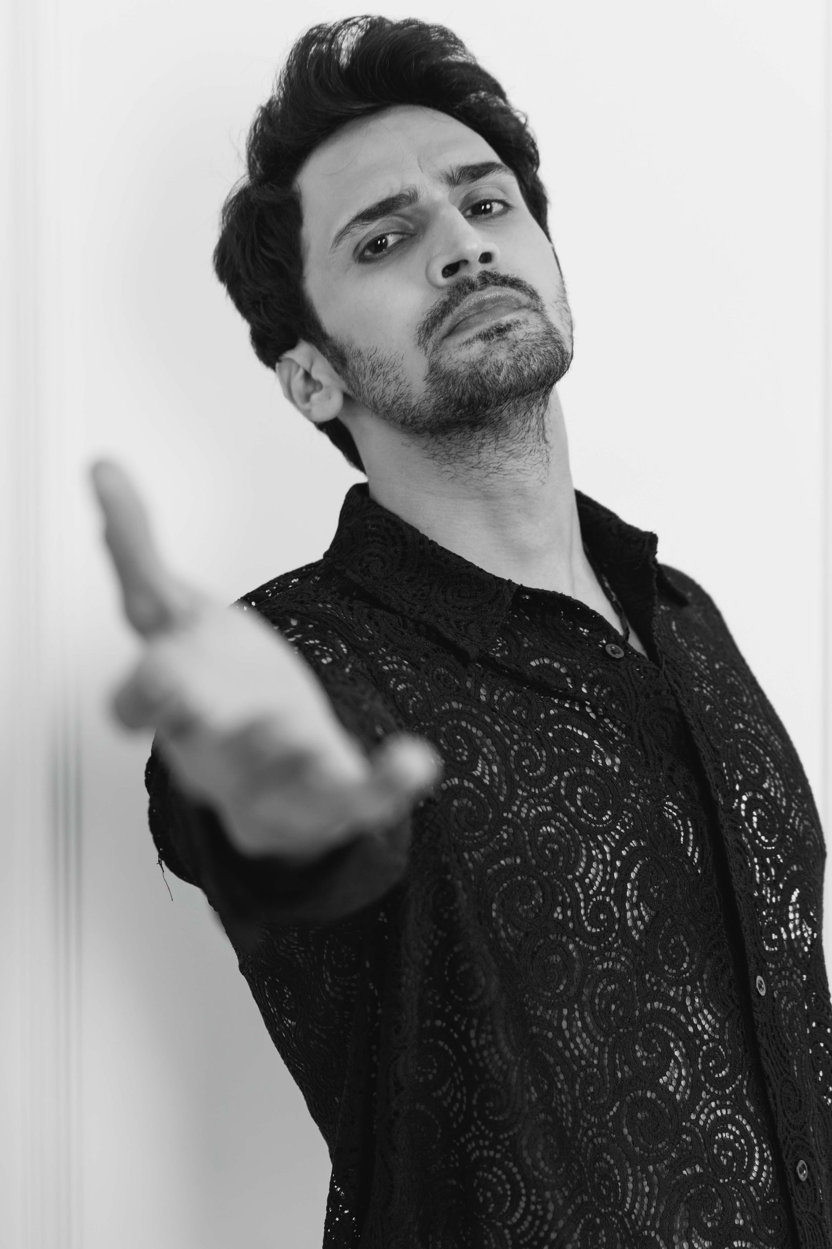 Black-and-white portrait, hand extended towards the lens
