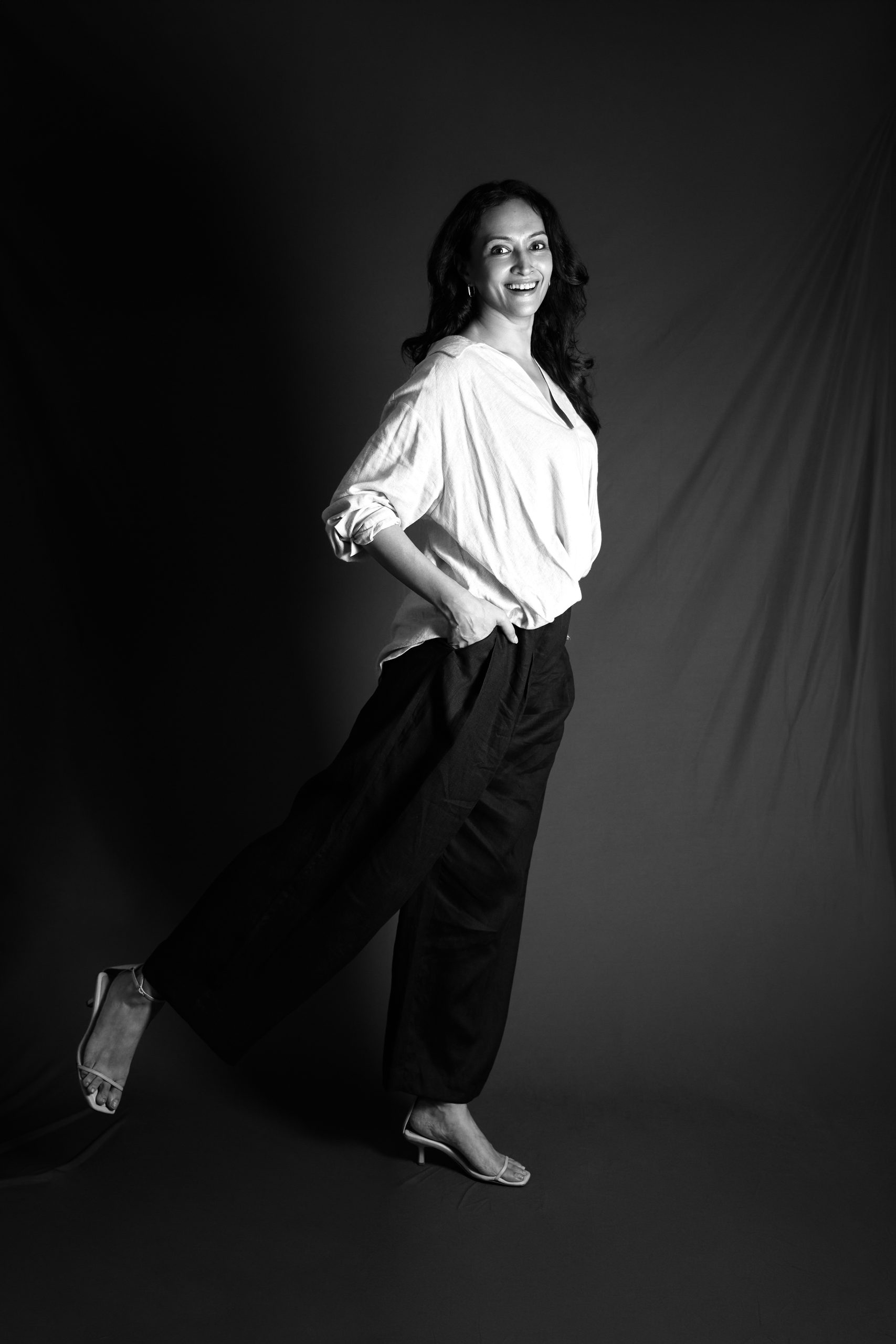 Black-and-white studio portrait against a dark ground
